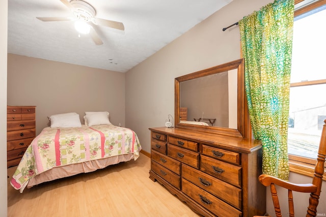 bedroom featuring multiple windows, light hardwood / wood-style floors, and ceiling fan