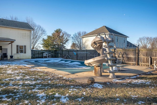 snow covered pool featuring a patio area and a playground