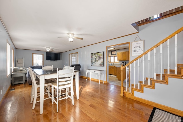 dining room featuring light hardwood / wood-style flooring, ornamental molding, and ceiling fan