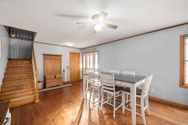 dining space with crown molding, ceiling fan, and light hardwood / wood-style flooring