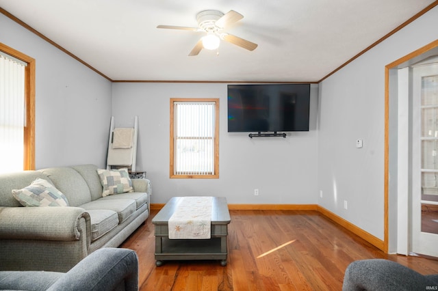 living room with hardwood / wood-style floors, ornamental molding, and ceiling fan