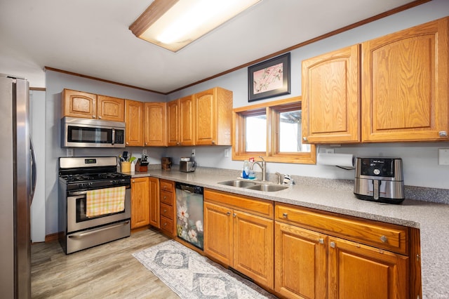 kitchen featuring ornamental molding, stainless steel appliances, sink, and light hardwood / wood-style flooring