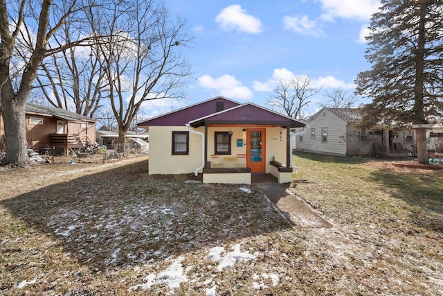 view of front of house with covered porch and a front lawn