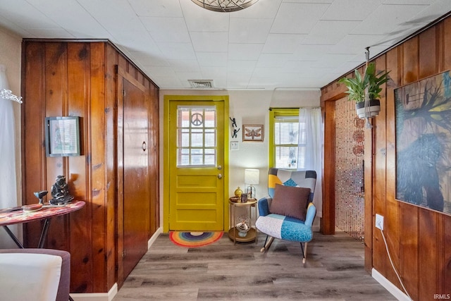 living area with hardwood / wood-style flooring and wooden walls