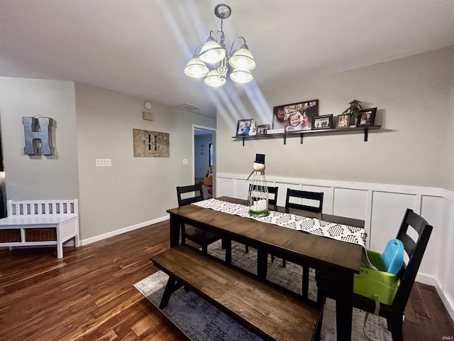 dining room with dark hardwood / wood-style floors and a chandelier