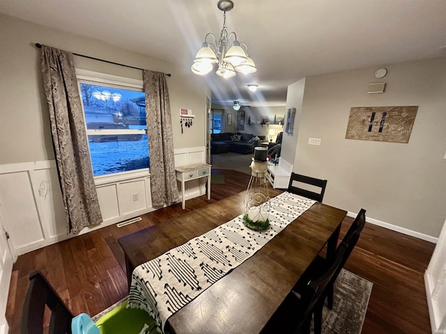 dining room with dark wood-type flooring and a notable chandelier