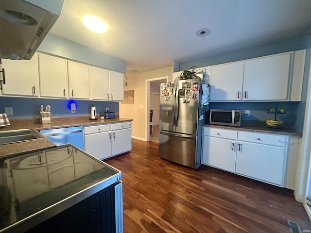 kitchen featuring dark wood-type flooring, sink, white cabinetry, stainless steel appliances, and exhaust hood