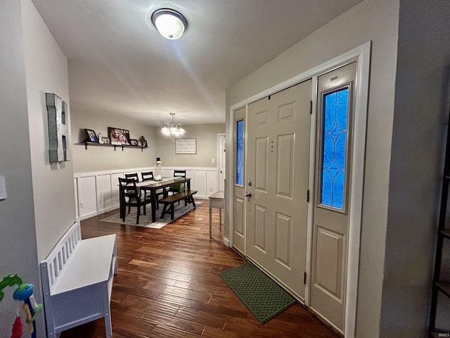 foyer featuring dark wood-type flooring and an inviting chandelier