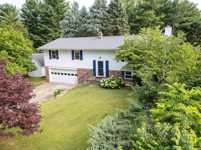 split foyer home featuring a garage and a front yard