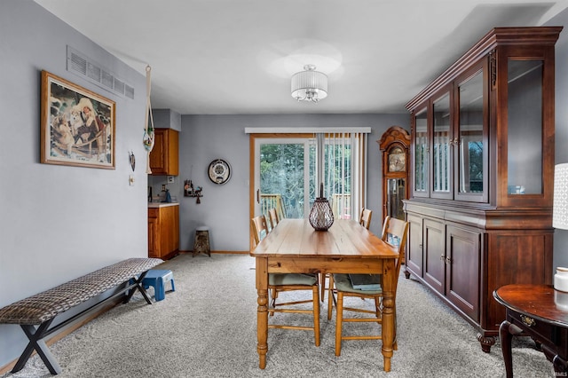 dining area featuring light carpet