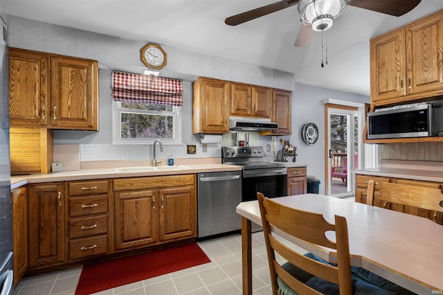 kitchen with sink, light tile patterned floors, ceiling fan, appliances with stainless steel finishes, and decorative backsplash