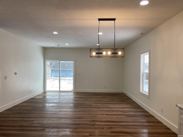 empty room featuring dark wood-type flooring and a textured ceiling