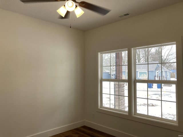 empty room with ceiling fan and dark hardwood / wood-style floors