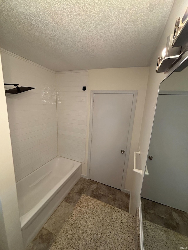 bathroom with  shower combination and a textured ceiling