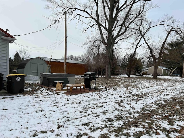 snowy yard featuring a hot tub