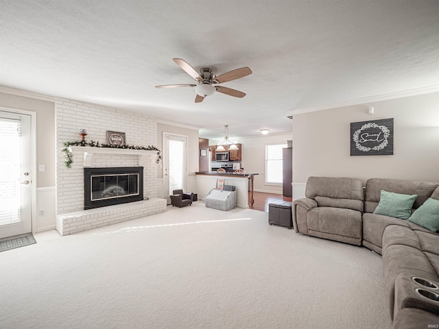 living room featuring ornamental molding, a healthy amount of sunlight, and a brick fireplace