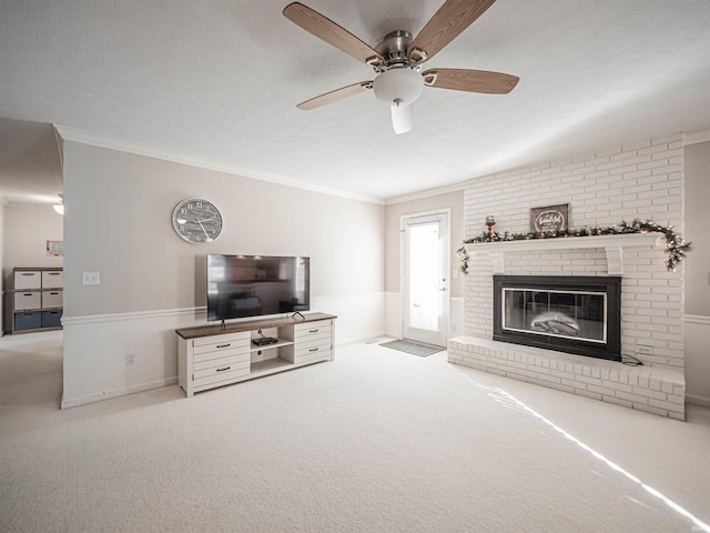 carpeted living room featuring crown molding, ceiling fan, and a brick fireplace