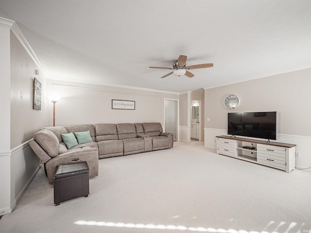 carpeted living room with ceiling fan and ornamental molding