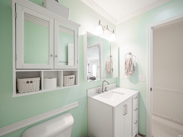 bathroom with vanity, crown molding, and toilet