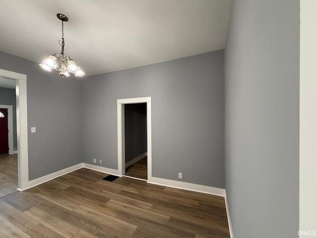 unfurnished room featuring wood-type flooring and a chandelier