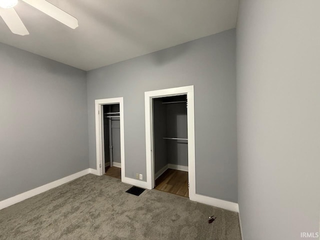 unfurnished bedroom with ceiling fan, a walk in closet, dark carpet, and a closet