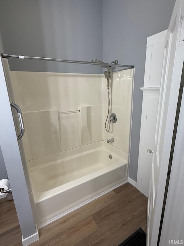 bathroom featuring hardwood / wood-style floors and  shower combination