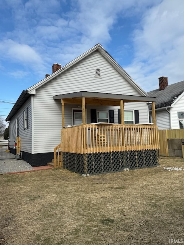 back of property with a wooden deck and a yard