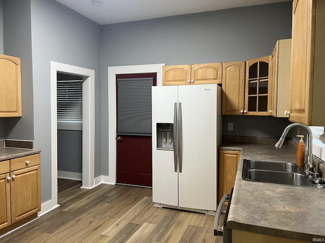 kitchen with hardwood / wood-style flooring, white refrigerator with ice dispenser, and sink