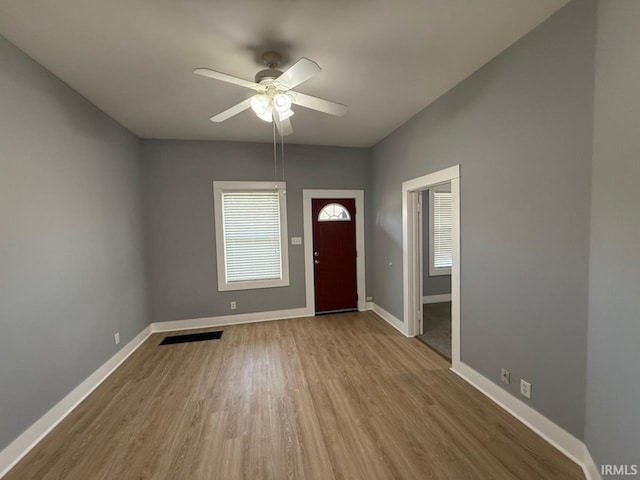 foyer entrance with ceiling fan and light hardwood / wood-style flooring