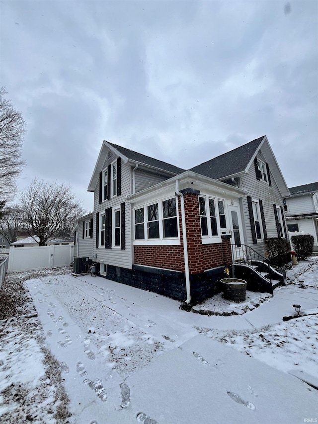 view of snow covered exterior with central AC unit