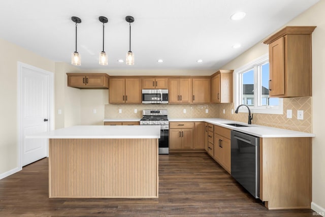 kitchen featuring appliances with stainless steel finishes, dark hardwood / wood-style floors, decorative light fixtures, sink, and a center island