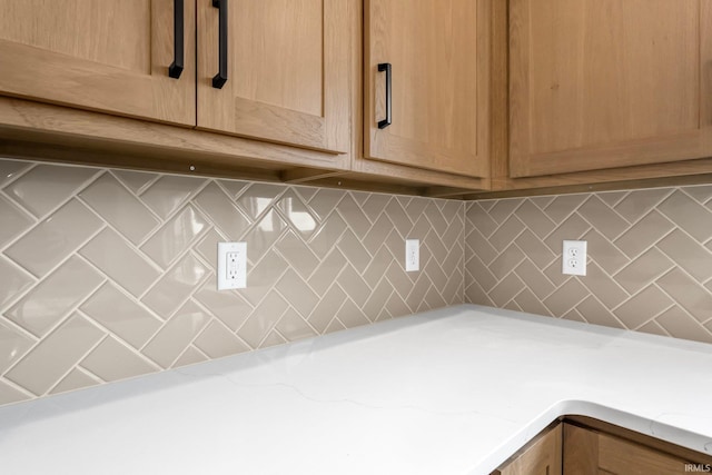 room details featuring tasteful backsplash and light stone countertops