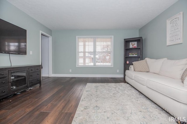 living room with dark hardwood / wood-style flooring and a textured ceiling