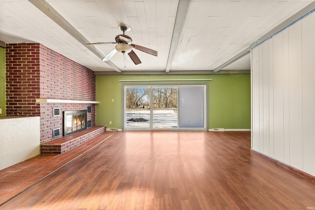 unfurnished living room with ceiling fan, hardwood / wood-style flooring, a fireplace, and beamed ceiling