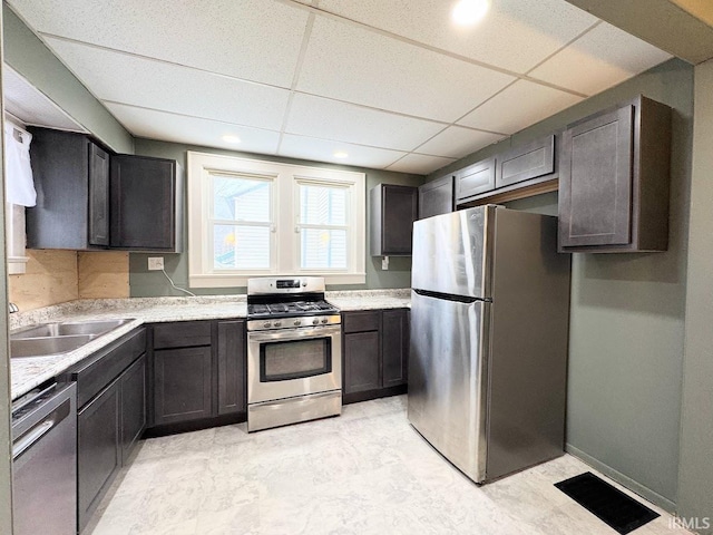 kitchen featuring appliances with stainless steel finishes, sink, a paneled ceiling, and dark brown cabinetry