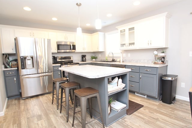 kitchen featuring pendant lighting, sink, gray cabinetry, white cabinets, and stainless steel appliances