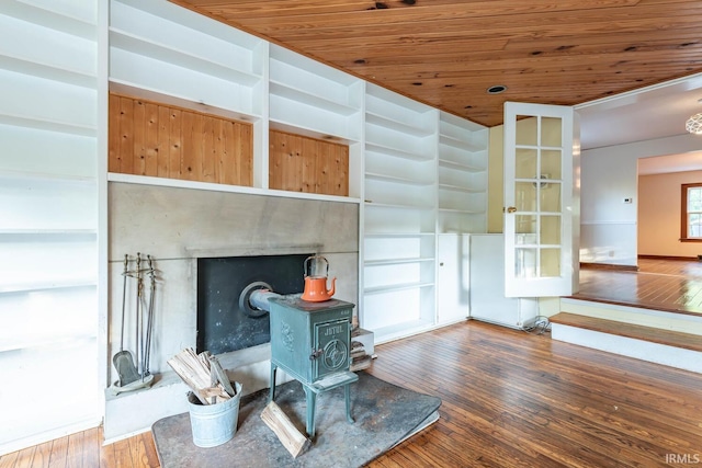 interior space with wooden ceiling, hardwood / wood-style floors, and a wood stove