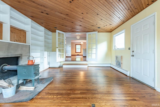 living room with dark hardwood / wood-style flooring, wood ceiling, built in shelves, and a wood stove