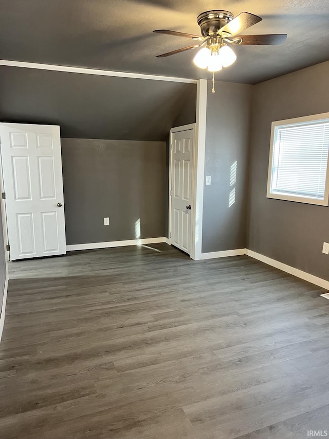 additional living space with hardwood / wood-style floors, vaulted ceiling, and ceiling fan