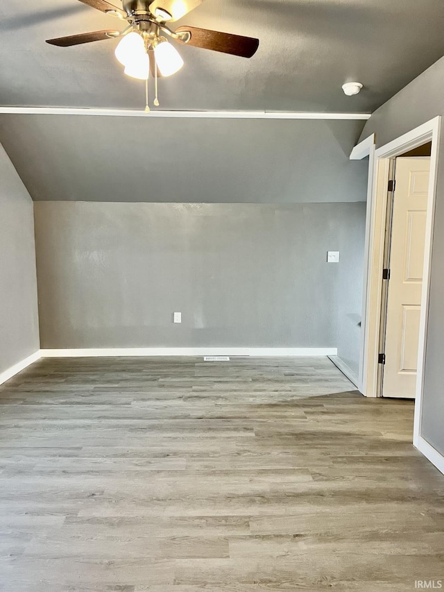 additional living space with vaulted ceiling, light hardwood / wood-style floors, and ceiling fan