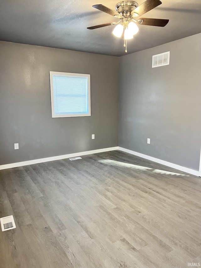 spare room with hardwood / wood-style flooring and ceiling fan