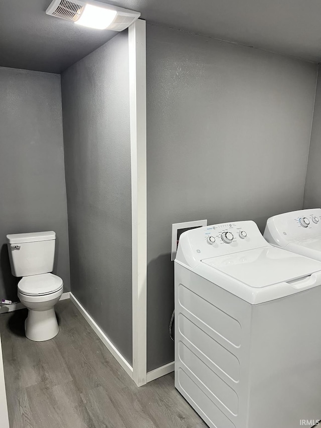 laundry area with washer and clothes dryer and hardwood / wood-style floors