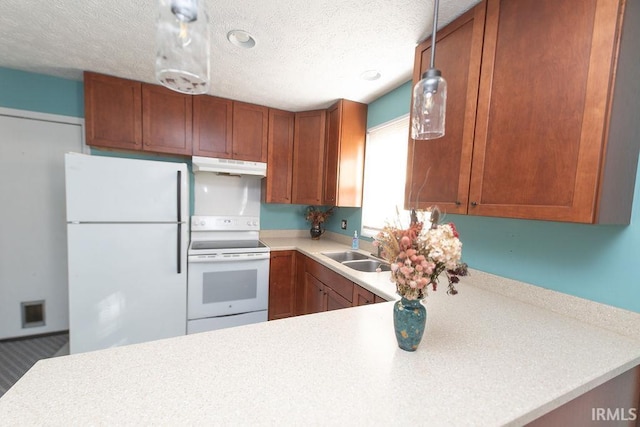 kitchen featuring sink, white appliances, kitchen peninsula, and a textured ceiling