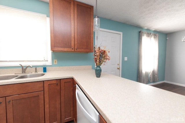 kitchen featuring stainless steel dishwasher, sink, and a textured ceiling