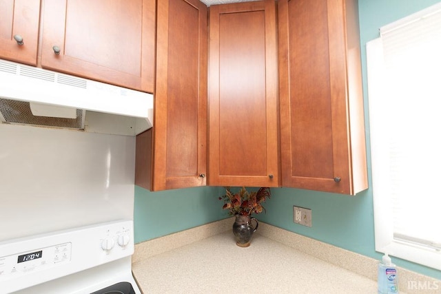 kitchen featuring stacked washer and clothes dryer and range