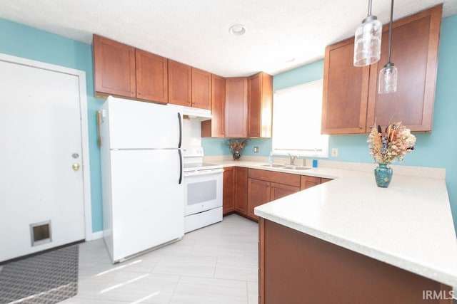 kitchen with pendant lighting, white appliances, sink, and a textured ceiling