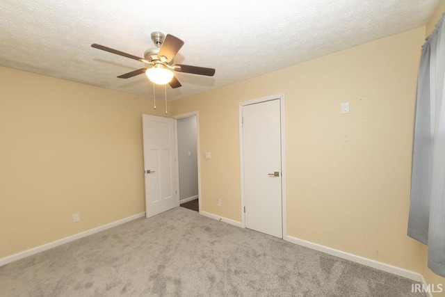 carpeted empty room featuring ceiling fan and a textured ceiling