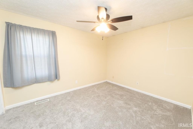 carpeted spare room featuring a textured ceiling and ceiling fan