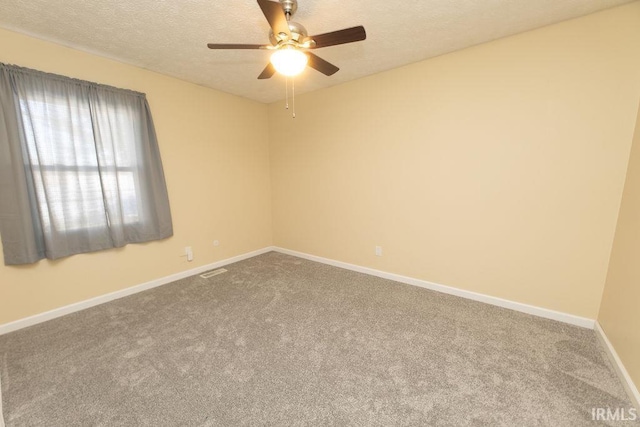 carpeted spare room with ceiling fan and a textured ceiling