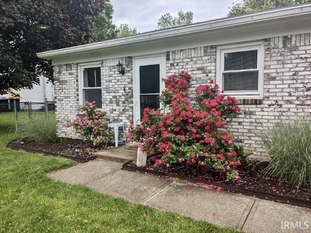 entrance to property featuring a lawn